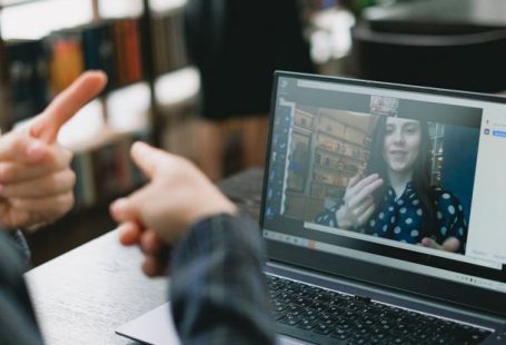 Language Acquisition - Young lady learning sign language during online lesson with female tutor