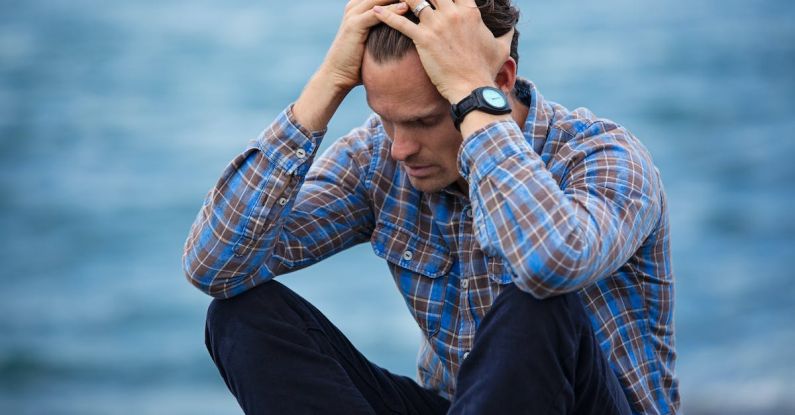 Unemployment - Man in Blue and Brown Plaid Dress Shirt Touching His Hair